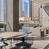 a patio with a table and chairs and a pool with tall buildings in the background
